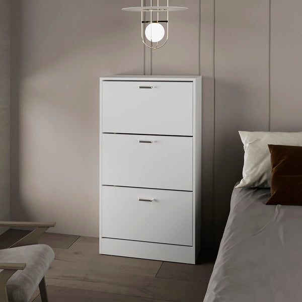 White tall dresser with three drawers in a bedroom